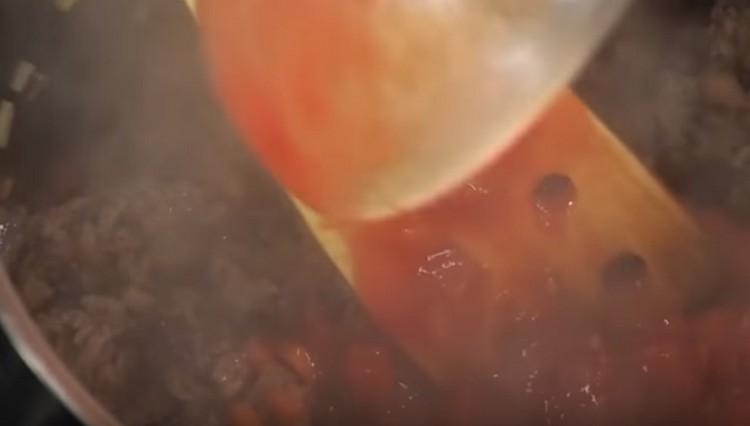 Add chopped tomatoes to the minced vegetables.