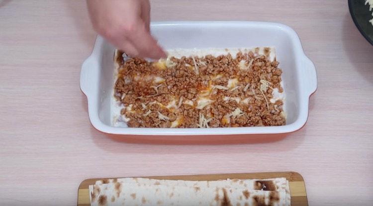 Sprinkle the minced meat with grated cheese.