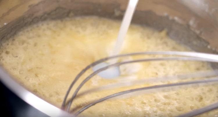 Next, we introduce milk and mix the mass, breaking the lumps.