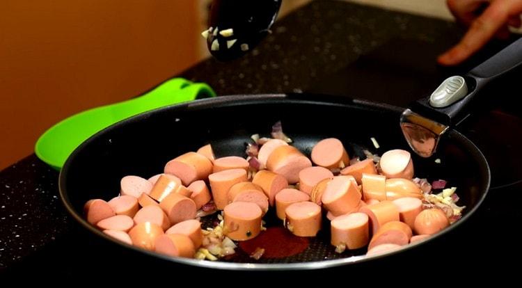 Add sausages to the onion.