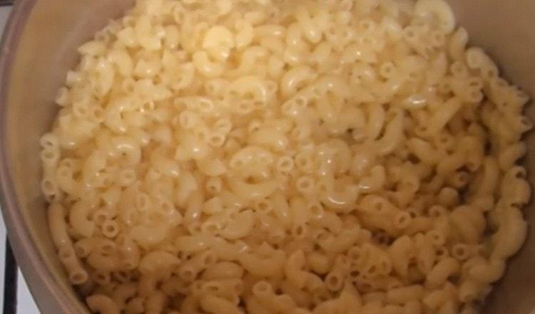 We discard the almost finished pasta into a colander and return it to the pan for a while.