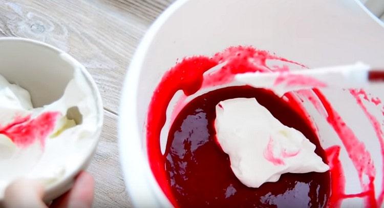 We take the cream out of the refrigerator and mix it in raspberry jelly in portions.