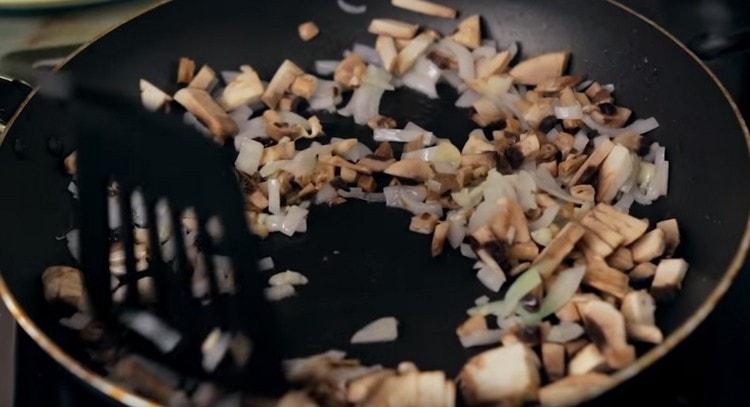 Add garlic and mushrooms to the onion, fry together.