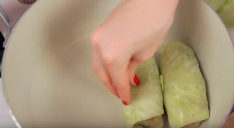 Spread cabbage rolls in a deep pan.