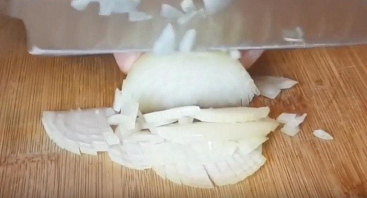 We chop the onion with a knife.