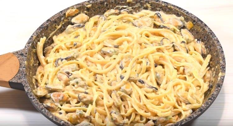 Appetizing pasta with mussels in a creamy sauce is ready.