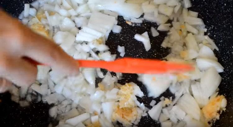 Fry onion with garlic in a pan.