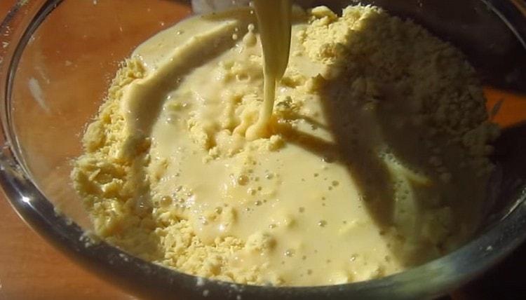 Pour the liquid ingredients into the butter and flour crumbs.