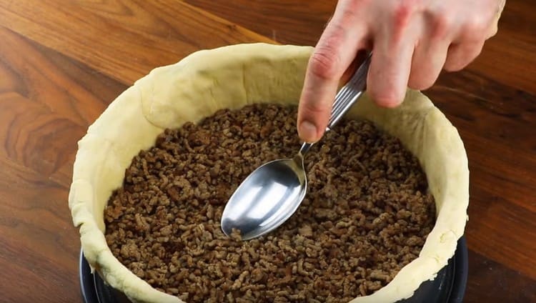 We spread the mince on the dough.