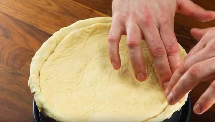 Cover the filling with a second layer of dough, pinch the edges.