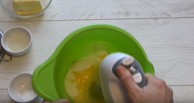 Beat eggs with sugar using a mixer.