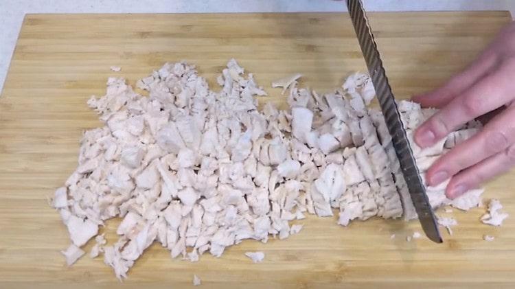 Cut the boiled chicken fillet into pieces.