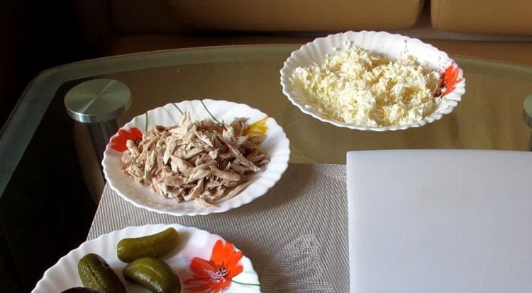 Tear the boiled chicken into fibers, and grate the eggs.