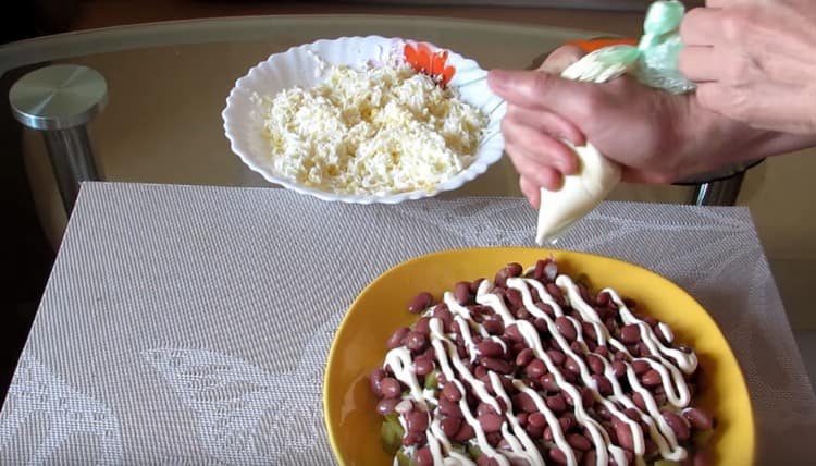 Next, lay out a layer of beans and cover with mayonnaise.