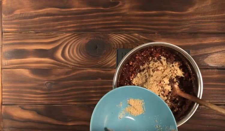 In a chocolate mass we spread a mixture of cookies and nuts, mix.