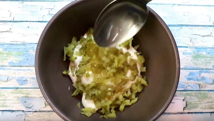 We add chopped cucumbers and wine vinegar to mayonnaise.
