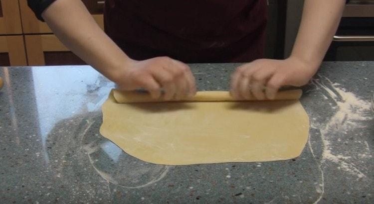 Sprinkle the finely rolled dough with flour and roll it up with a loose roll.