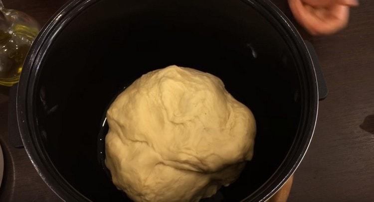We shift the dough into the multicooker bowl, greased with vegetable oil, and leave for proofing.
