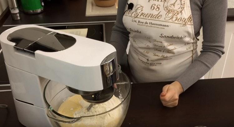 We spread the dough, the remaining flour and egg mass into the bowl of the food processor and knead the dough.