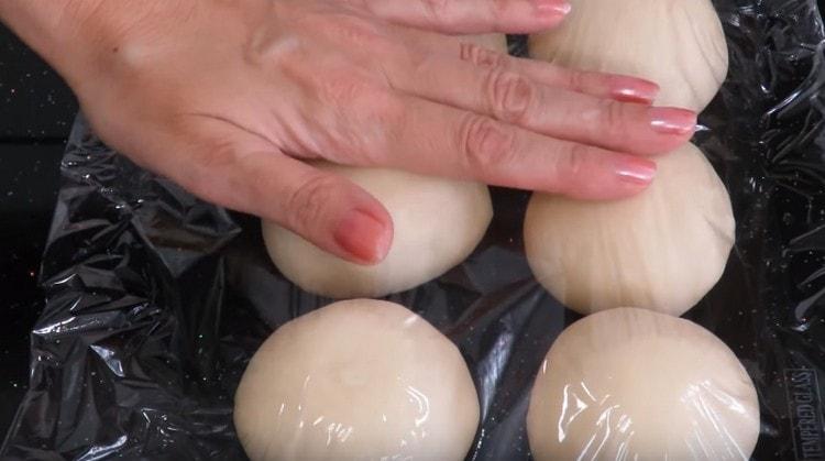 We cover the balls of dough with a film and leave.
