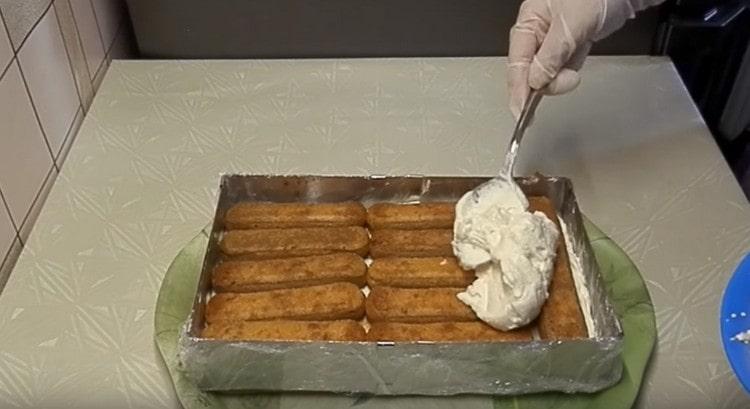 lay out another layer of soaked savoyardi and again cover it with cream.