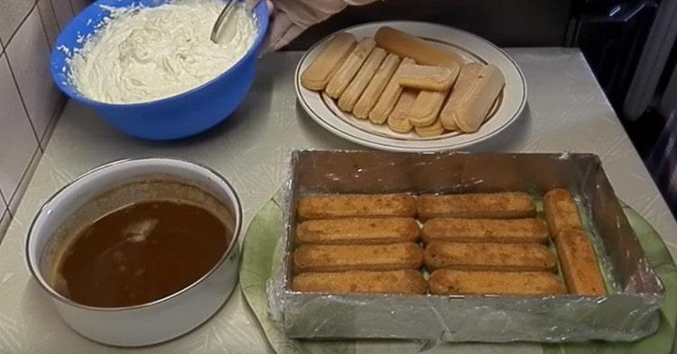 We spread the soaked Savoyardi coffee in a detachable form.