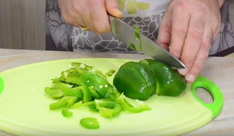 While the meat and onions are fried, chop the bell pepper in strips.