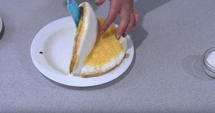 carefully cutting the omelet, cover with the free half the one on which there is cheese.