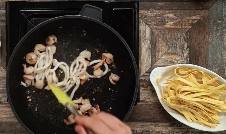 Fry seafood to make fettuccine