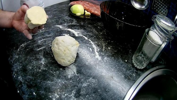 Knead the dough to make chebureks