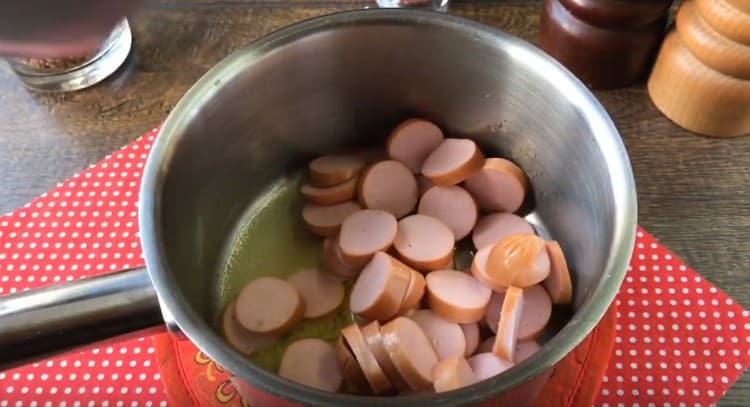 Cut sausages into circles and spread in a saucepan.