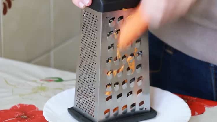 Grate carrots to make soup