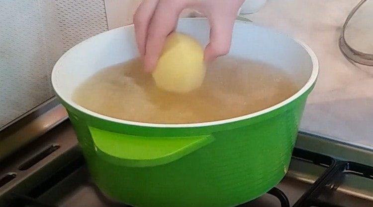 In a boiling broth we spread peeled, but whole potatoes.