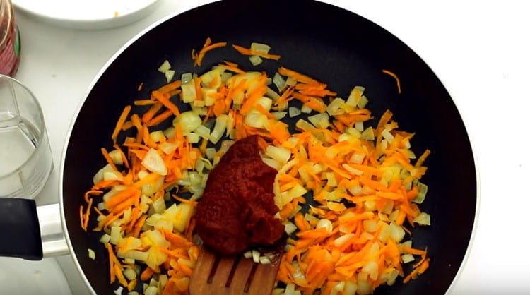 Add tomato paste to the vegetables.