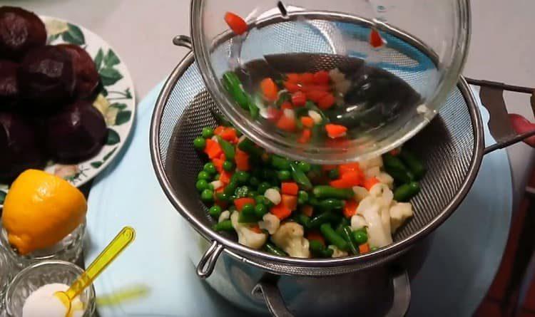 We discard boiled vegetables on a sieve.