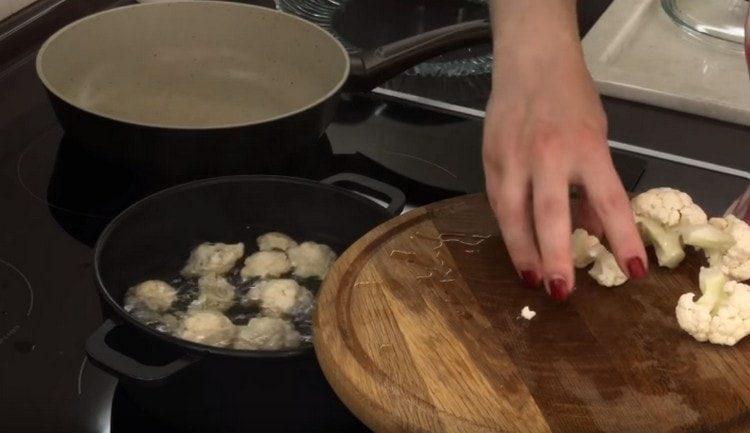 boiling water omit the inflorescences of cabbage and boil.