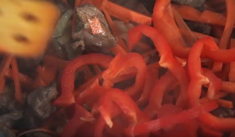 Add carrots to the meat, and then sweet pepper.