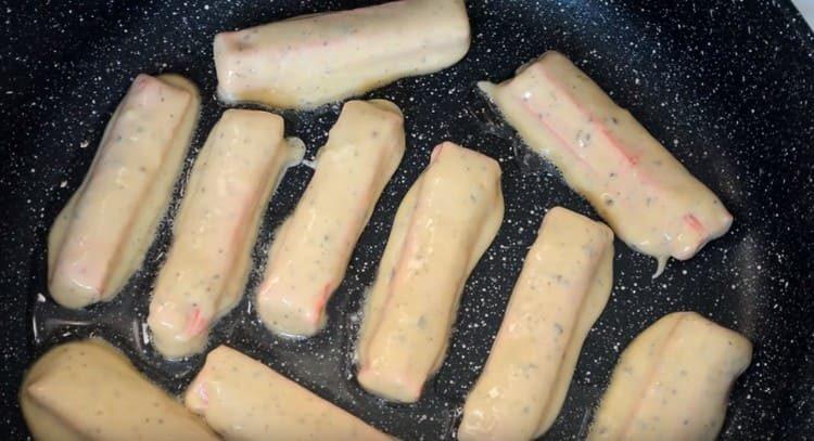 Dip crab sticks in batter and spread in a pan.
