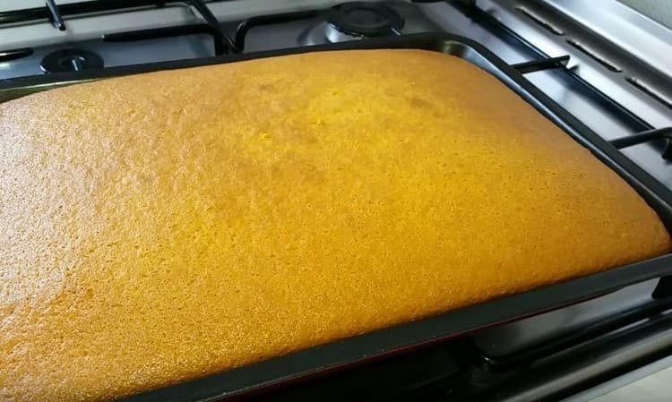 Bake the cake, then let it cool.