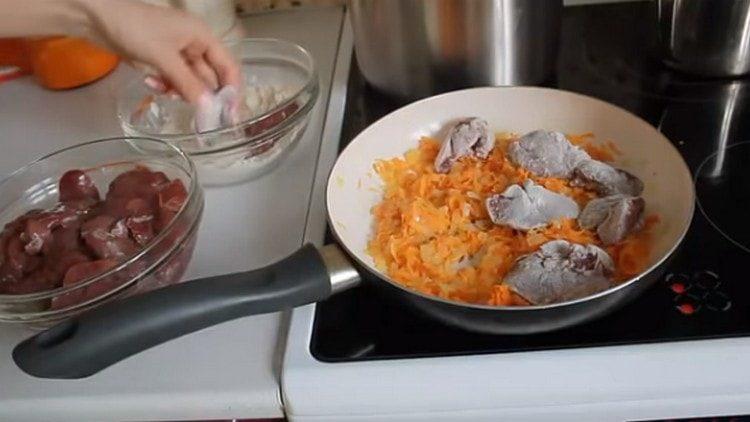 Pieces of liver roll in flour and spread in a pan for vegetables.
