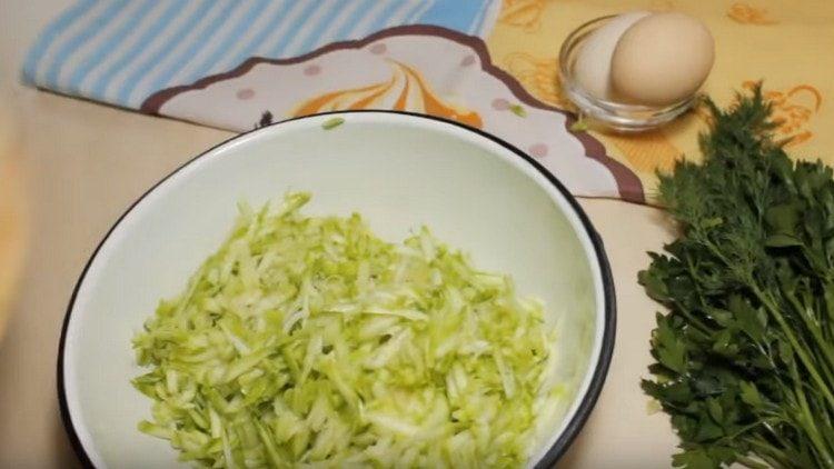 Three zucchini on a grater.