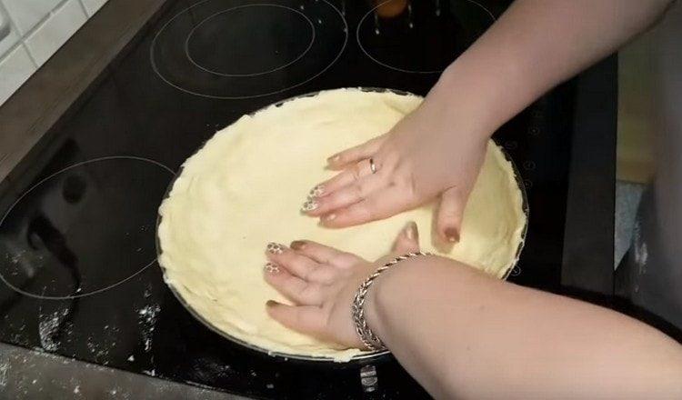 We put the dough into shape, make small sides.