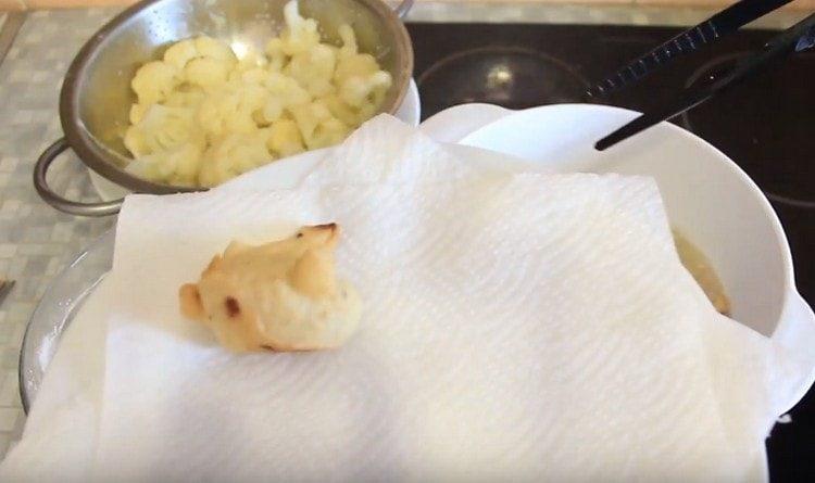 We transfer the fried inflorescences to paper towels.