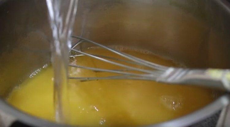 Pour orange juice and water into the stewpan.