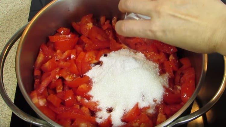 We put the tomatoes in a pan, add salt and sugar to them.