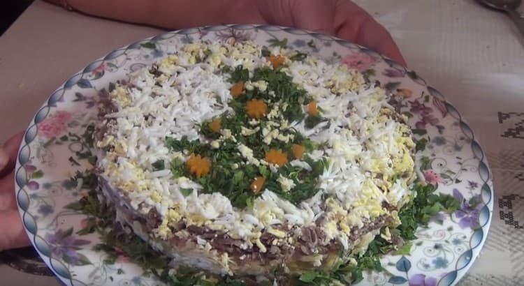 Garnish pork liver salad with grated egg and herbs.