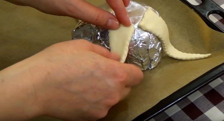 From the pieces of dough we form the tentacles of an octopus on a cup.