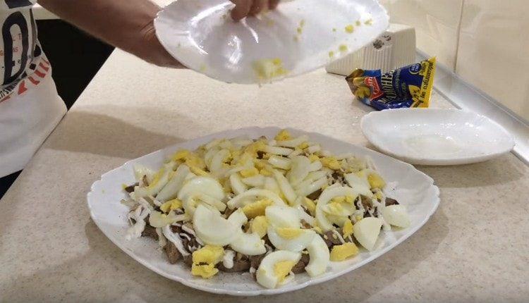 Lay eggs on top of the onion and grease with mayonnaise.