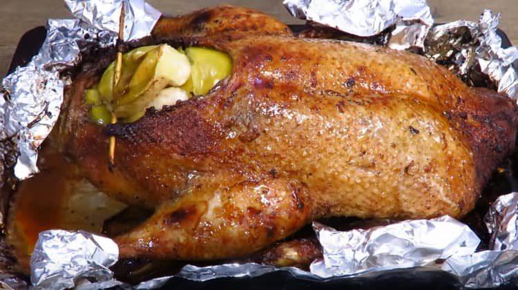 So that the legs and wings of the duck are not burnt, we wrap them in foil.