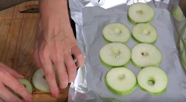 Cut the apples into thin circles and spread on a baking sheet covered with foil.